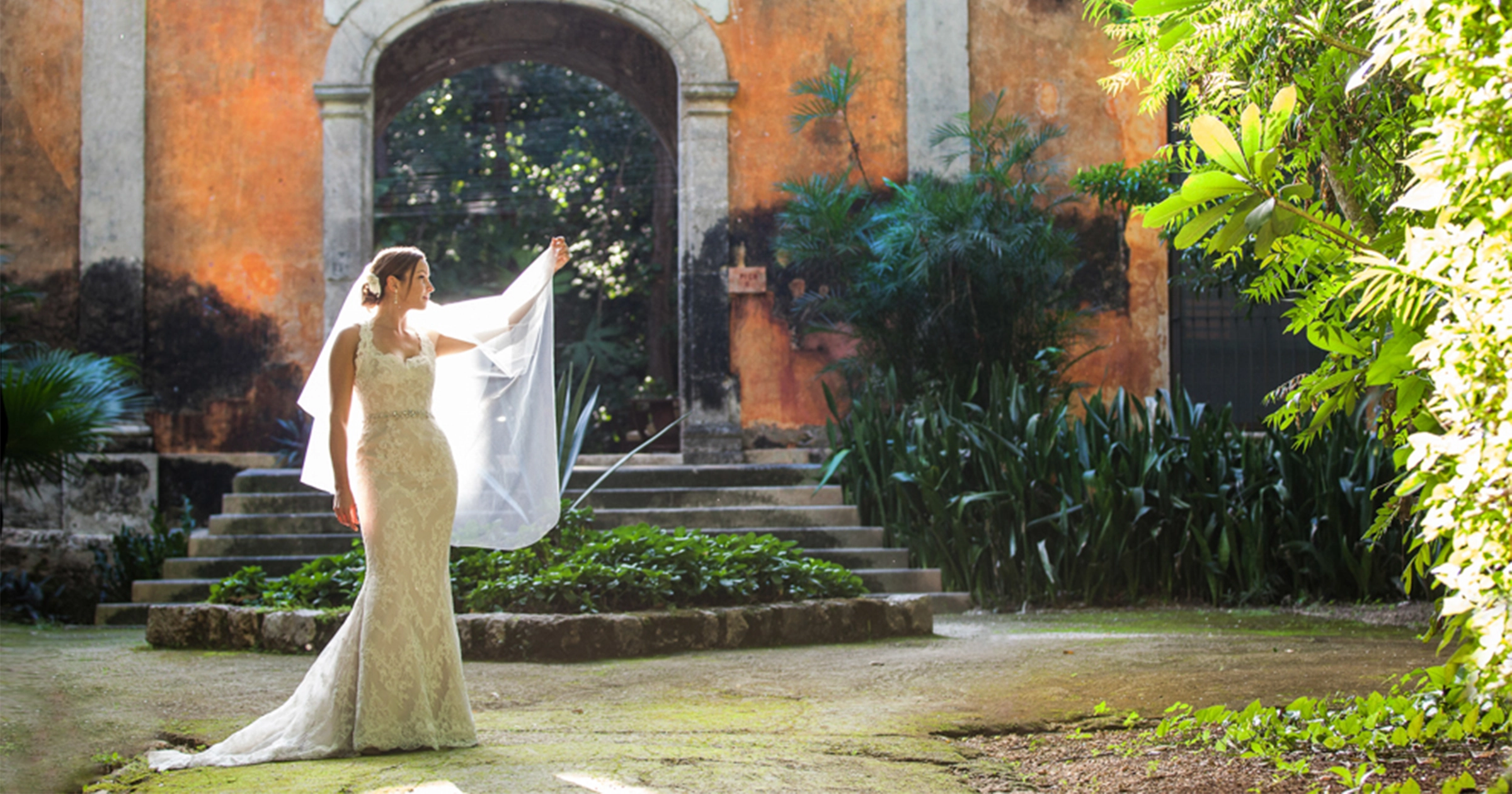 Newlywed couple walking down Calle 59 among painted facades in the walled city of Campeche, Mexico