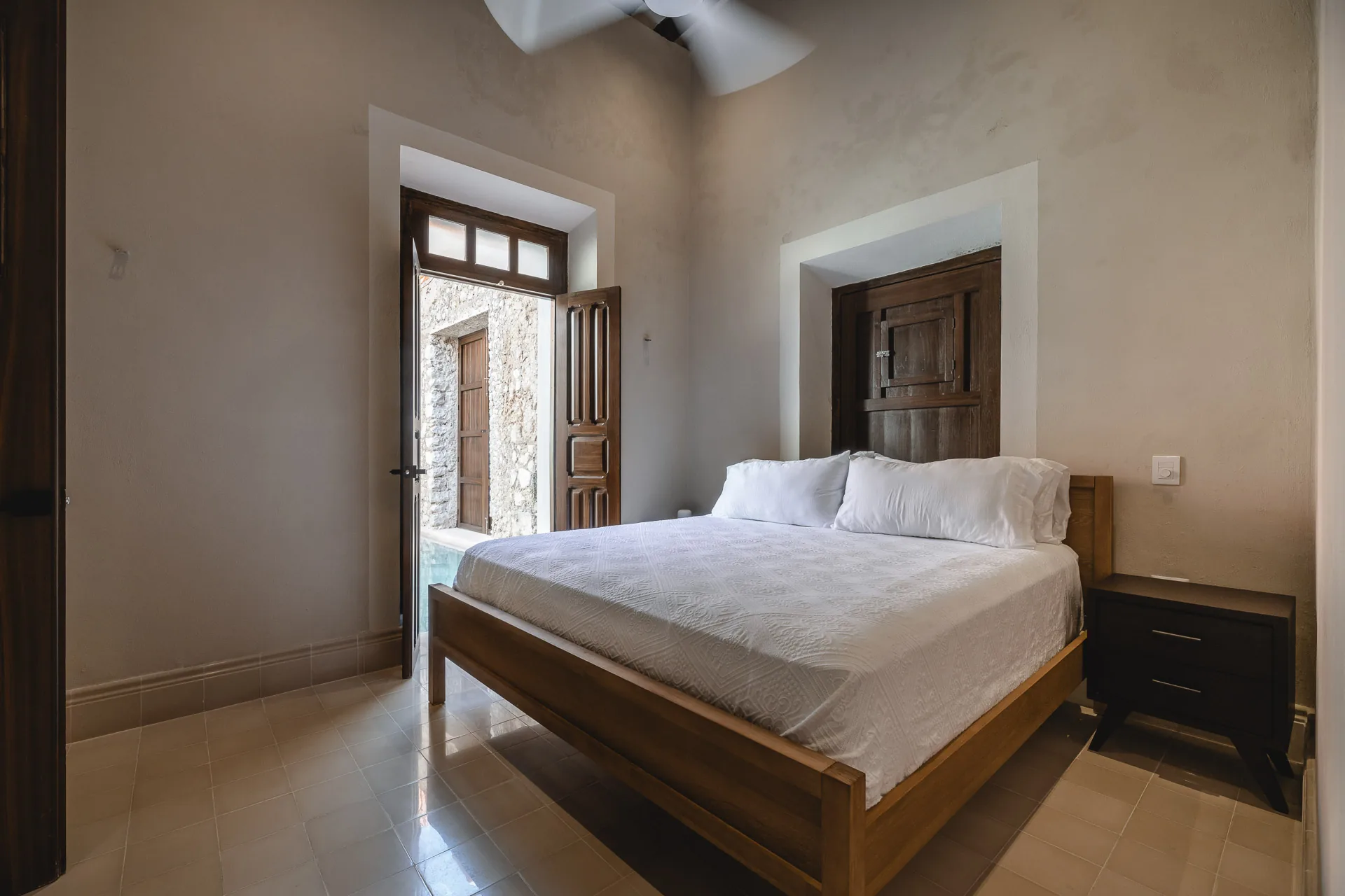 Bedroom with restored stone walls at Casa Ex Templo — Casonas MX