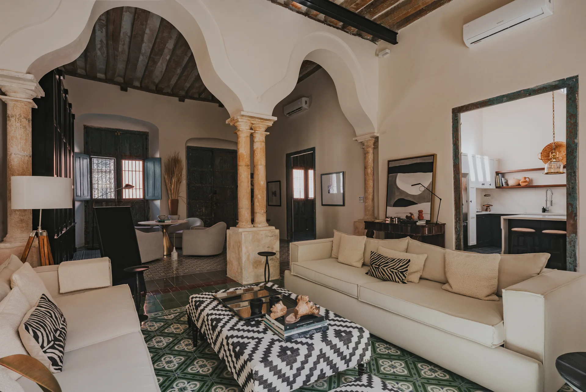 Sala principal restaurada con columnas, arcos coloniales y muros originales en una casa patrimonial de Campeche — Casonas MX