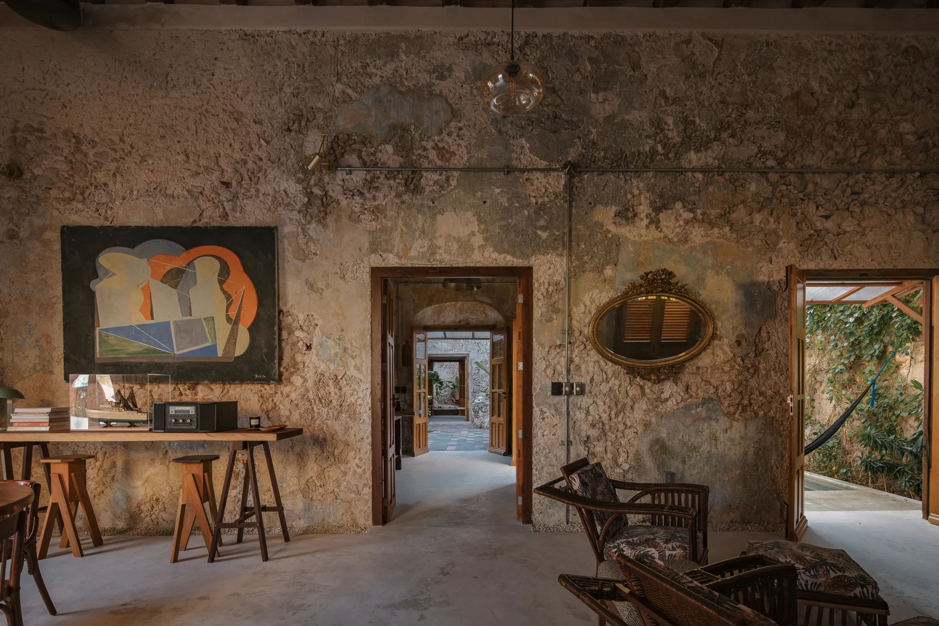 Sala con muros de piedra y techo de vigas de madera en una casa histórica restaurada de Campeche — Casa Zotz by Casonas MX